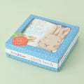 Peter Rabbit cloth book packaging with blue polka dot design on a light green background